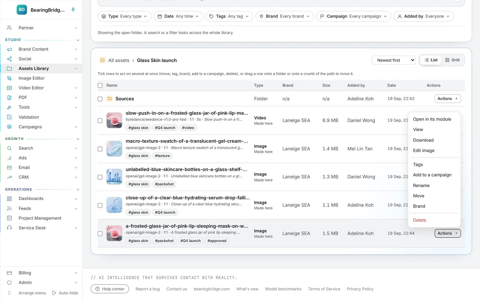 Assets in the Glass Skin launch folder: a subfolder, then a generated clip and images, each showing its engine, shape, prompt, and tags, with an Actions menu open: open in its module, view, download, edit image, tags, rename, move, brand, delete